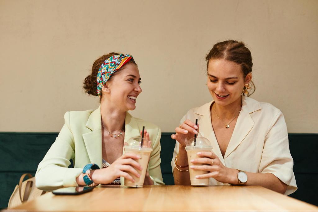 two women friends talking laughing coffee"