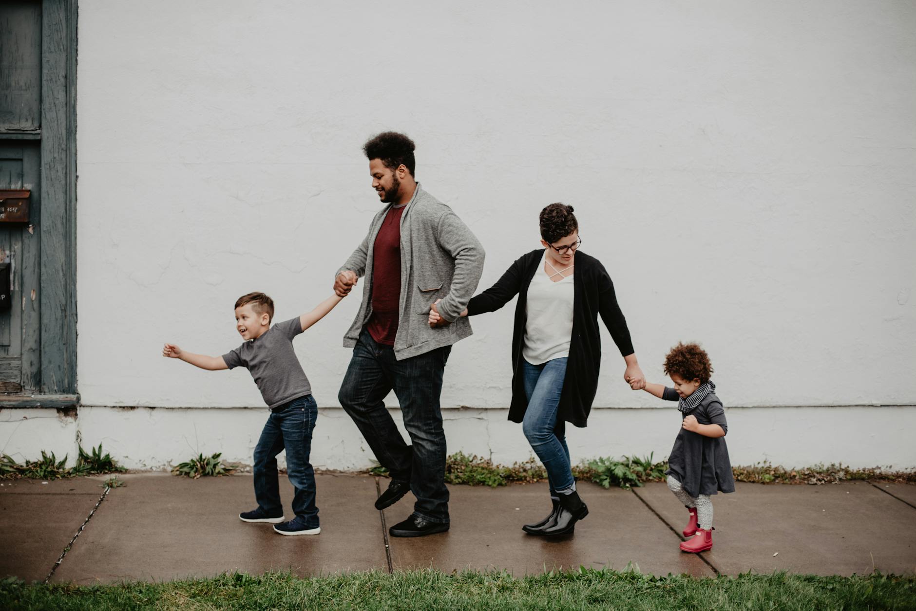 mom, dad and children taking a walk while holding hands