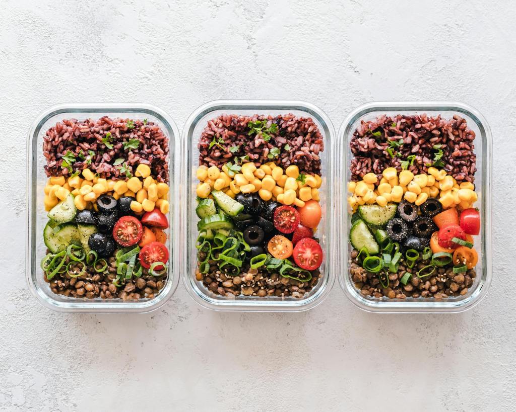 meal prep lunches with legumes, tomatoes, onion, corn, cucumber rice and chicken