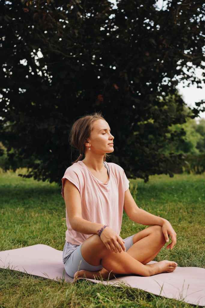 Woman on yoga mat deep breathing outside